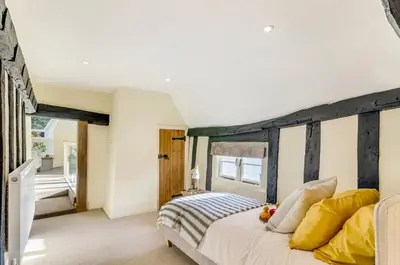 a bedroom with a large bed with yellow pillows at 5 Bedroom House in Larling, near Thetford in Norwich