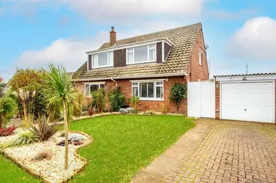 a brick house with a white garage at Kittiwake, Aldeburgh - Aldeburgh Coastal Cottages in Aldeburgh