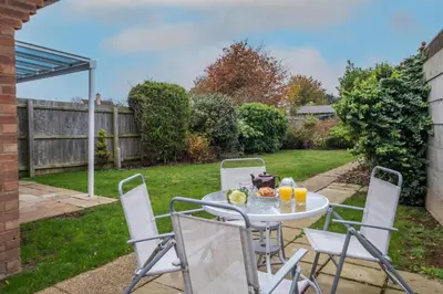 a table and chairs in the backyard of a house at Kittiwake, Aldeburgh - Aldeburgh Coastal Cottages in Aldeburgh