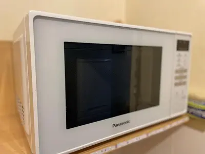 a microwave oven sitting on top of a shelf at Cosy central 1 bedroom flat near city centre & station in Cambridge