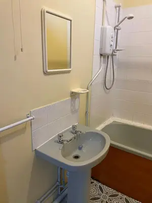 a bathroom with a sink and a mirror and a tub at Cosy central 1 bedroom flat near city centre & station in Cambridge