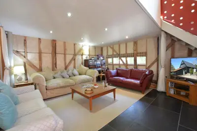 a living room with two couches and a tv at Yew Tree Farm Barn, Worlingworth in Worlingworth