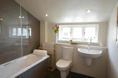 a bathroom with a toilet and a sink and a tub at Yew Tree Farm Barn, Worlingworth in Worlingworth