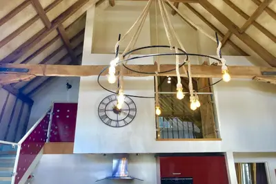 a clock hanging from the ceiling of a building at Yew Tree Farm Barn, Worlingworth in Worlingworth