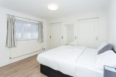 a white bedroom with a large bed and a window at The White & Warm, Free Parking & Wifi, 8 beds in Colchester