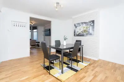 a dining room with a black table and chairs at The White & Warm, Free Parking & Wifi, 8 beds in Colchester