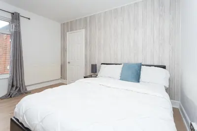 a bedroom with a large white bed with a blue pillow at The White & Warm, Free Parking & Wifi, 8 beds in Colchester