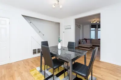a dining room and living room with a table and chairs at The White & Warm, Free Parking & Wifi, 8 beds in Colchester