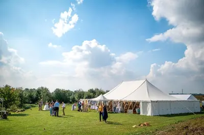 a group of people standing around a tent in a field at Willow Cottage at Gravel Farm in Stretham