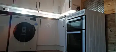 a kitchen with a stove and a dishwasher at Cosy Cabin in Stock