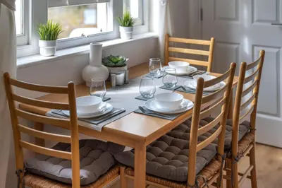 a dining room table with chairs and a wooden table and chairsuggest at 2BR Apartment Near Stansted Airport & Bishop Stortford in Bishops Stortford