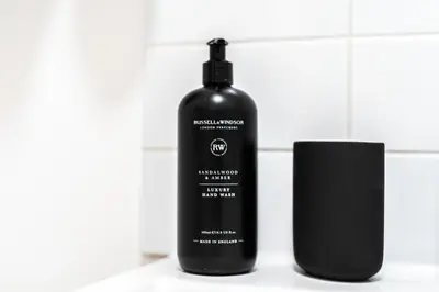 a black bottle of shampoo next to a black container at 2BR Apartment Near Stansted Airport & Bishop Stortford in Bishops Stortford