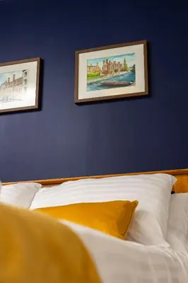 a bedroom with two pictures on the wall and a bed at The Black Horse in Swaffham Bulbeck