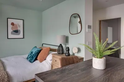 a bedroom with a bed and a table with a plant at Studio Apartment - Central Chelmsford Location in Chelmsford