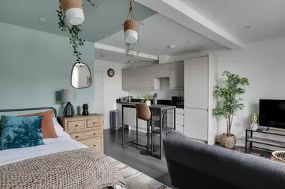 a living room with a bed and a kitchen at Studio Apartment - Central Chelmsford Location in Chelmsford
