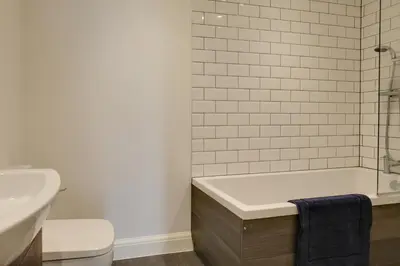 a bathroom with a tub and a toilet and a sink at Studio Apartment - Central Chelmsford Location in Chelmsford