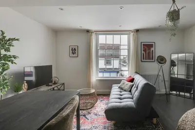 a living room with a table and a couch at Studio Apartment - Central Chelmsford Location in Chelmsford