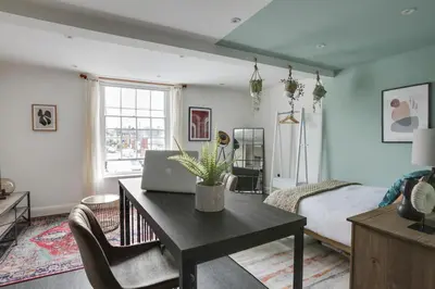 a room with a desk with a laptop on it at Studio Apartment - Central Chelmsford Location in Chelmsford