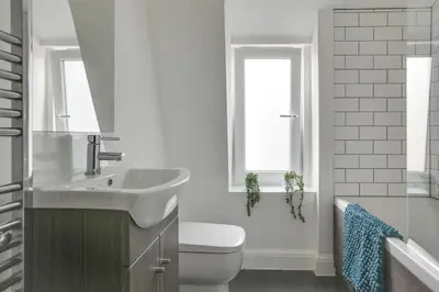 a white bathroom with a sink and a toilet at Cosy Chelmsford Apartment - Free Allocated Parking in Chelmsford