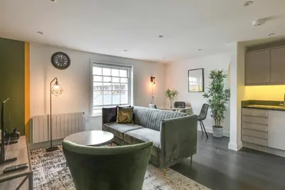 a living room with a couch and a table at Cosy Chelmsford Apartment - Free Allocated Parking in Chelmsford