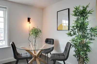 a dining room with a glass table and chairs at Cosy Chelmsford Apartment - Free Allocated Parking in Chelmsford