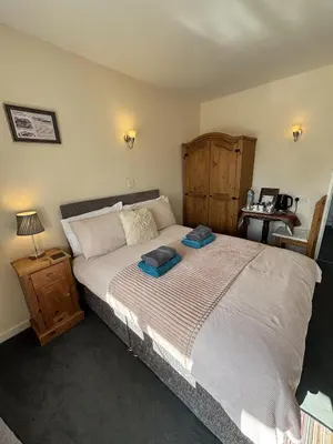 a bedroom with a large bed and a wooden cabinet at The Half Moon Inn Rushall IP21 4QD in Pulham Saint Mary the Virgin
