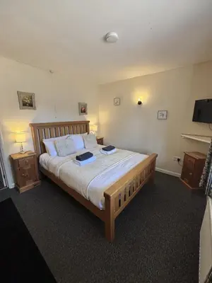 a bedroom with a large bed and two night stands at The Half Moon Inn Rushall IP21 4QD in Pulham Saint Mary the Virgin