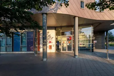 a large building with glass windows and a pole at For Students Only Collegiate Athena Hall Ipswich in Ipswich