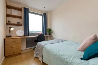 a bedroom with a bed and a desk and a window at For Students Only Collegiate Athena Hall Ipswich in Ipswich