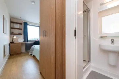 a bathroom with a sink and a bed in a room at For Students Only Collegiate Athena Hall Ipswich in Ipswich