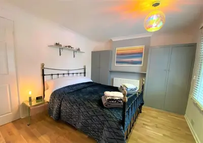 a bedroom with a bed and a painting on the ceiling at Gulliver's Cottage in Frinton-On-Sea in Frinton-on-Sea