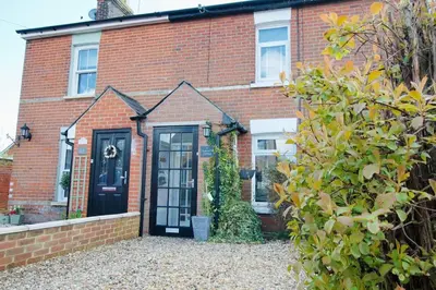 a red brick house with a black door at Gulliver's Cottage in Frinton-On-Sea in Frinton-on-Sea