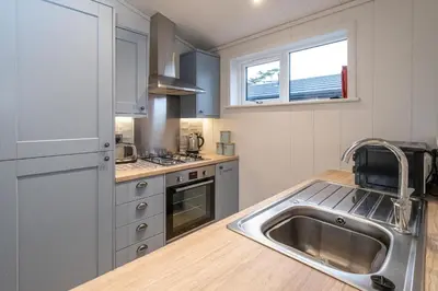 a kitchen with a sink and a counter top at Beach Lodge - Aldeburgh Coastal Cottages in Sizewell