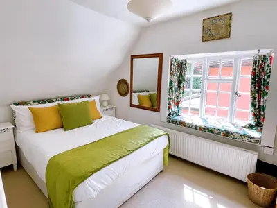 a bedroom with a bed and a window at The Peacock Inn in Chelsworth
