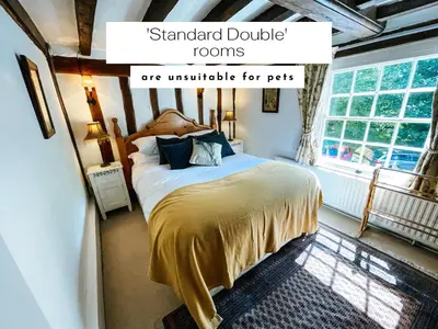 a bedroom with a bed and a window at The Peacock Inn in Chelsworth