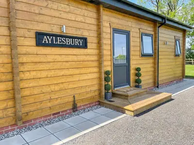 a sign on the side of a wooden house at Aylesbury Lodge in Halstead