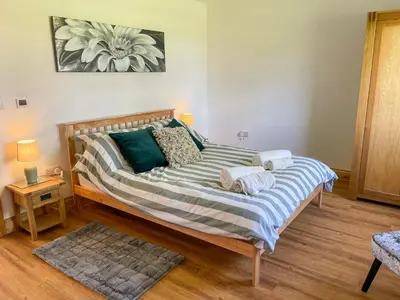 a bedroom with a large bed with towels on it at Aylesbury Lodge in Halstead