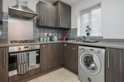 a kitchen with a washer and a washing machine at Stunning 3BR house in Basildon in Basildon