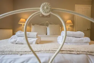 a bedroom with a bed with white towels on it at The Farmhouse Boundary Farm Framlingham in Woodbridge