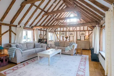 a living room with two couches and a table at The Hayloft Boundary Farm, Framlingham in Woodbridge