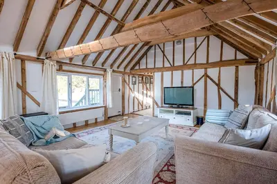 a living room with two couches and a tv at The Hayloft Boundary Farm, Framlingham in Woodbridge