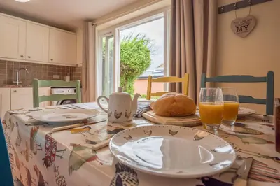 a dining room table with plates and glasses of orange juice at The Hayloft Boundary Farm, Framlingham in Woodbridge