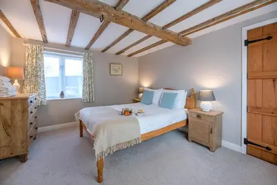 a bedroom with a large bed and a window at The Hayloft Boundary Farm, Framlingham in Woodbridge