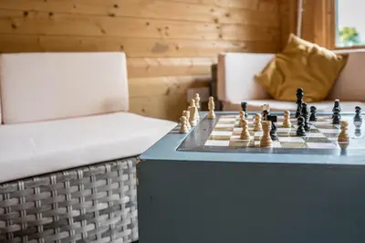 a chess game on a table next to a chair at The Hayloft Boundary Farm, Framlingham in Woodbridge