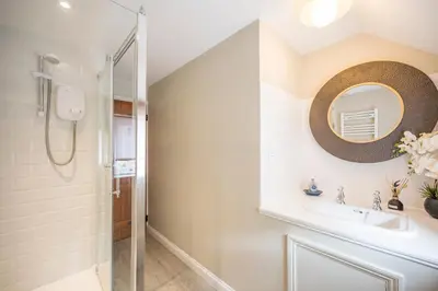 a bathroom with a sink and a mirror at The Hayloft Boundary Farm, Framlingham in Woodbridge