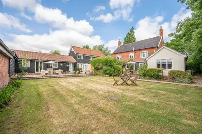 a backyard of a house with a yard sidx sidx at The Cartlodge Boundary Farm, Framlingham in Woodbridge
