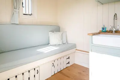 a bench in a kitchen with a sink at Sage Shepherds Hut Boundary Farm, Framlingham in Woodbridge