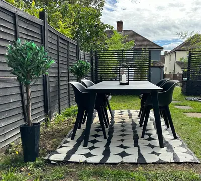 a table and chairs in a backyard with a fence at 2 Bedroom Garden Studio in Cambridge City Centre with Parking in Cambridge