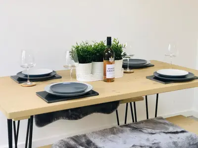 a table with plates and wine glasses on it at 2 Bedroom Garden Studio in Cambridge City Centre with Parking in Cambridge