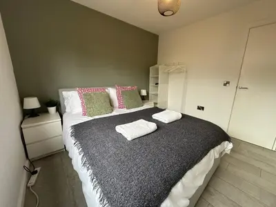 a bedroom with a large bed with two pillows at 2 Bedroom Garden Studio in Cambridge City Centre with Parking in Cambridge